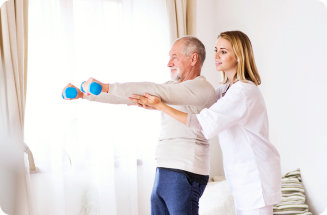 Physiotherapist helping a senior man exercise with dumbbells