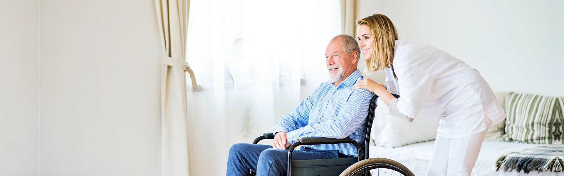 Nurse and a senior man in a wheelchair during home visit