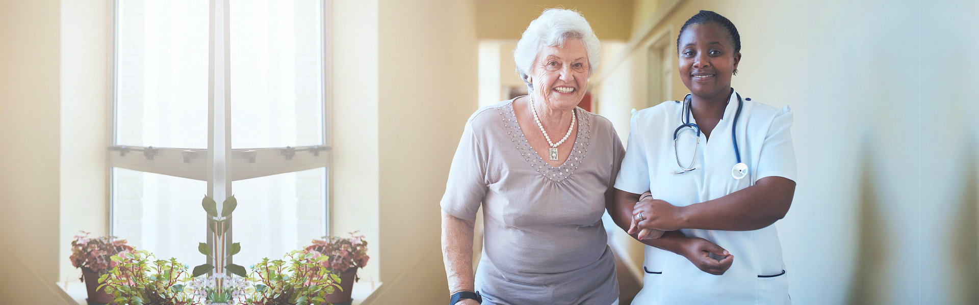 Caring female nurse assisting a senior patient to walk